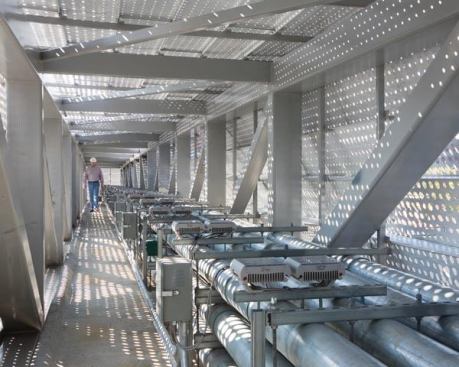 The interior of the bridge houses banks of electrical conduit and the interior of the zinc skin is painted white.