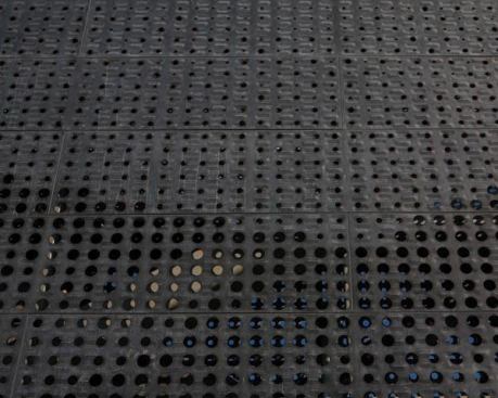 A detail view of the bridge’s zinc skin with a matte-black finish. A perforated pattern of holes, in different diameters, are set into a raised, relief texture.