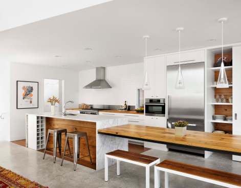 Warm wood tones complement the new kitchen's clean white palette.