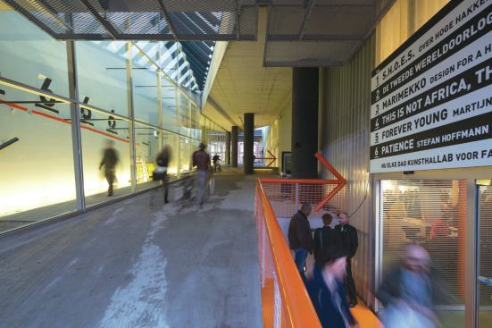 An open-air pedestrian pathway runs through the Kunsthal along the north–south axis. The new building entrance directs visitors into the restaurant.