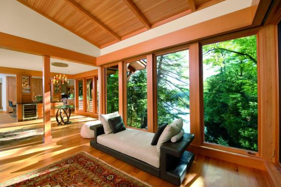 
  Nestled
  away adjacent to a lake, this lakeside residence is an example of fixed
  rusticity. The bright oak finish glows in comparison to the lush green forest
  beyond, creating a certain brightness throughout the home.