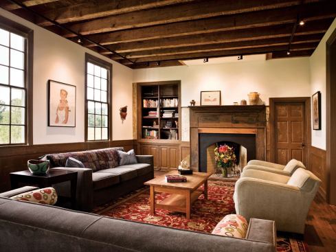 In the living room, track lighting brightens the space while leaving the old ceiling beams intact.