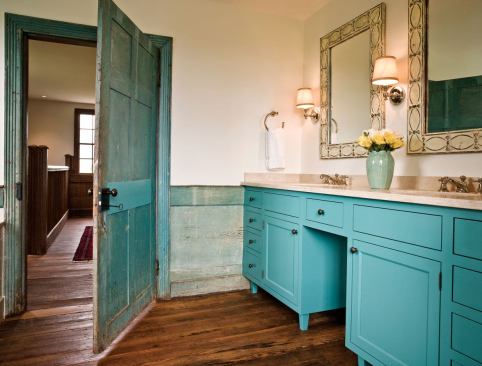 A sky-blue master bath complements the dark, salvaged wood floors.