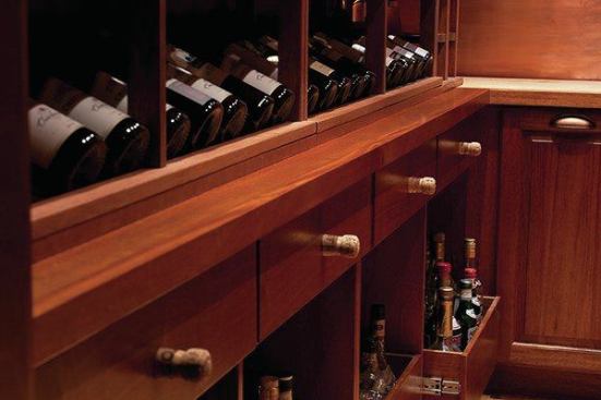 Below the racking system are a display shelf and pull out storage. Champagne corks as drawer pulls add a bit of whimsy.