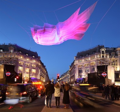 Janet Echelman’s sculpture "1.8" refers to the length of time in microseconds that the earth’s day was shortened as a result of the 2011 earthquake and tsunami that emanated from Japan. The work is composed of layers of fiber, braided and knotted together in vibrant hues that pulse with changing wind and weather to create a choreography of undulating color.