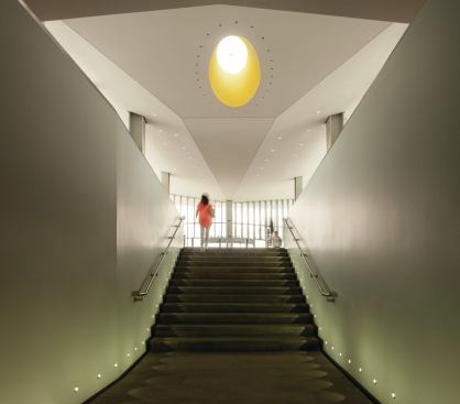 A stairwell in the library addition is capped by a yellow-painted oculus.