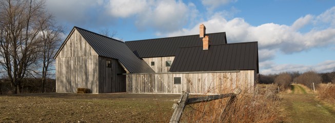 This 4,000-square-foot North Hatley, Quebec, farmhouse comprises three distinct volumes clad in repurposed hemlock sourced from dilapidated barns in Ontario.