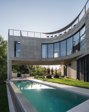 The upper volume wraps around the pool and shelters a terrace at the western end of the site.