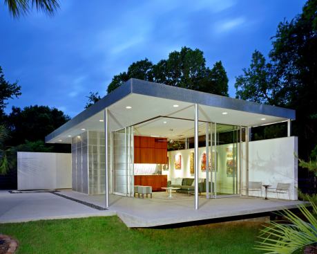Built for a pair of art dealers, this 620-foot structure pulls triple duty as a guest room, pool house, and art gallery. Two stucco perimeter walls provide hanging space for art, while the other two walls offer access to the pool and yard through full-height sliding glass doors. When needed, a Murphy Bed folds out to accommodate visitors. 
Architect: Steinbomer & Associates Architects, Austin, Texas 
Builder: MG Construction Works, Austin, Texas