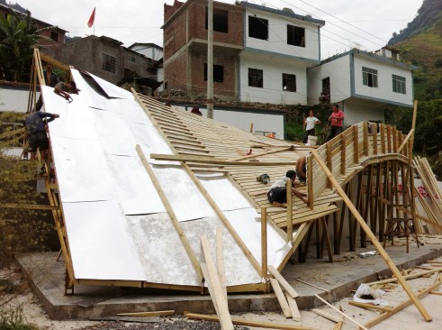 Workers covered the trusses with aluminum sheets and filled lap seams with sealant.