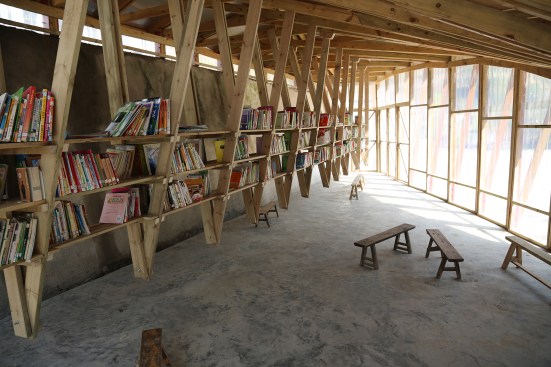 The roof trusses support 12 bays of wood bookshelves, each holding 200 books.