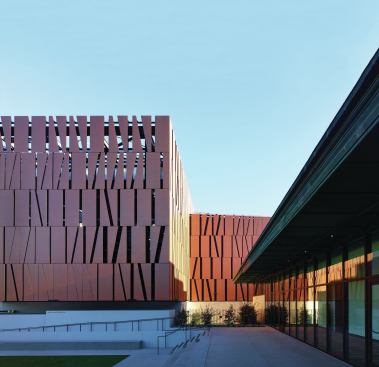 A row of glass-enclosed classrooms (at right) was tucked under the post office’s existing loading-dock canopy; these classrooms, along with the northern edge of the new theater (at left), frame the “education courtyard.”