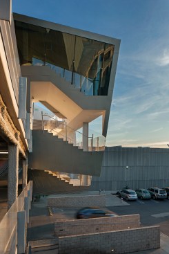 A stair projects from the west facade, offering access to offices and partly obscuring the existing parking garage.