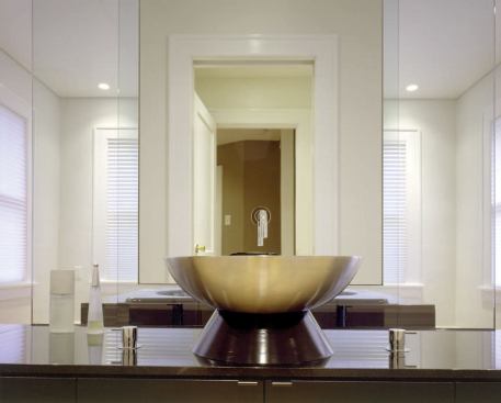 A painted MDF base raises the vessel lav off the lower-than-standard countertop height and up to a more comfortable position.