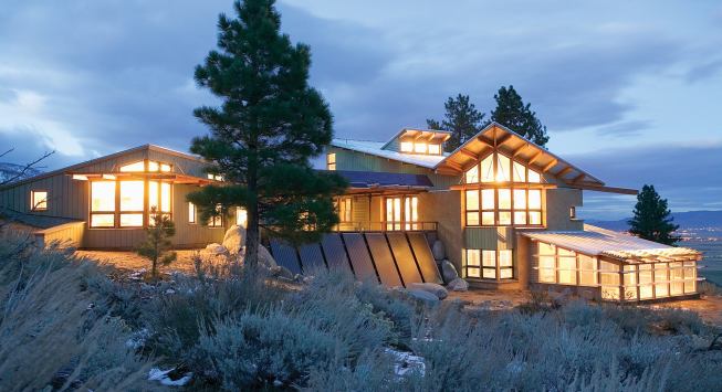 Photovoltaic panels generate electricity, and solar thermal panels combined with radiant sand beds beneath concrete slabs provide heat and hot water.