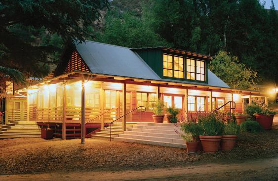 The old exterior cladding reappears as wainscoting in the new building, and the old doors are boiut into a frame that folds open like a Shoji screen, merging the main space with the screened porch.