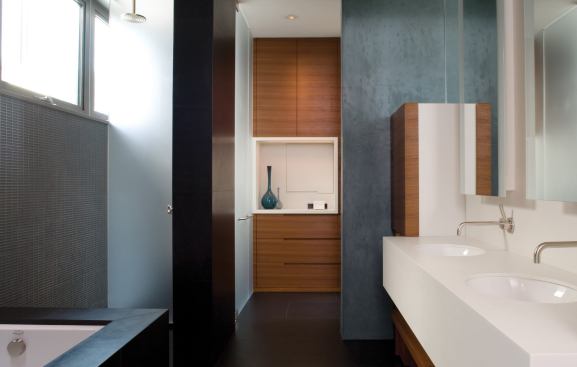A Corian sink counter inserts an island-likeelement between the master bedroom and bath. 