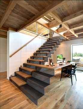 Architect Paul Masi wanted a “light, airy, and sculptural” look for the
stairs. Breitenbach
built it with risers made of the perforated blackened steel and white oak
treads, then installed it on site. The desk is suspended by a metal
cable railing system. 