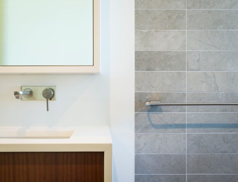 A Caesarstone wrap around the vanity and mirror help ground the pieces and visually connect them to each other in the grooming space.
