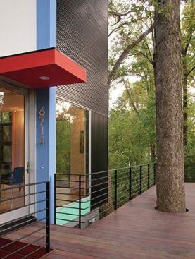 At the top of the gentle slope, a walkway leads from the sidewalk to this entryway on the deck, where a circular cutout gracefully accomodates a tree.