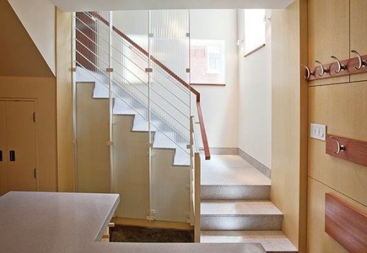 For the stair landing into the new basement, the clients saw an opportunity to create a railing that is a commissioned work of art. The stair granite matches the thresholds typical of the neighborhood’s historical entrances. The stair rail is by Wovensteel; the glass screen is from Bendheim, installed by Prestige Glass.
