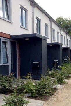 A renovated multifamily housing building with exterior mechanical rooms. The Energiesprong program retrofits often include new landscaping.