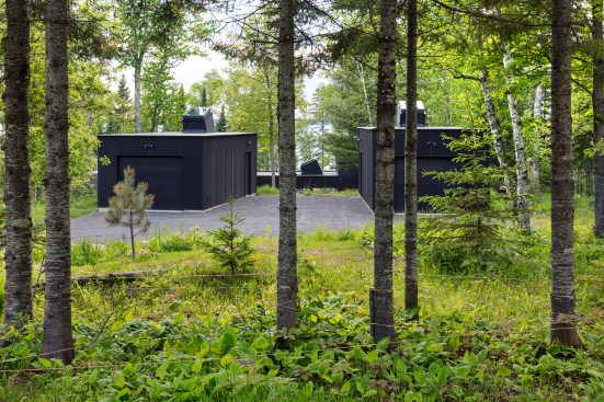 The garage and workshop and main house are clad in black Richlite panels and are connected via a stepped pathway.