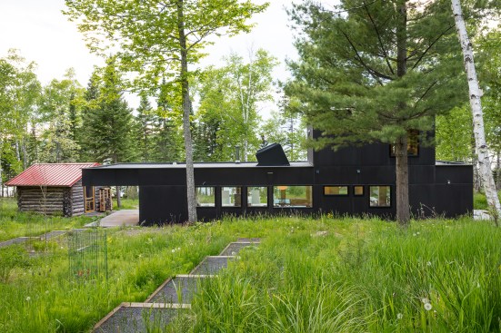 Main house seen from stepped path with existing cabin at left.