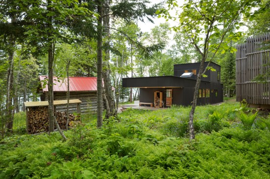 Main house entry at center with original cabin at left and reconfigured and reclad outhouse-turned-shower at right.