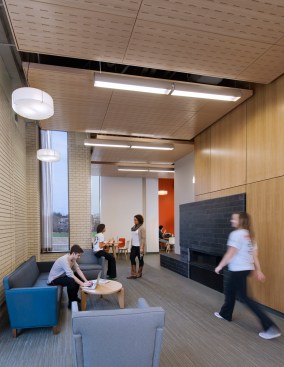 The common study area of Clerc Hall with a new fireplace, paneling, and lighting.