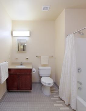 Baths feature ceramic tile, 1.5-gpm showerheads, and dual-flush toilets without gaskets for leak-free operation. A continuously operating energy recovery ventilator on the roof replaces stale and humid air with fresh air in each bathroom.