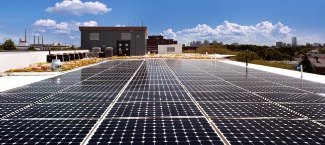 A 53-kW PV system of two flat roof arrays and one rail-mounted array covers 46% of the standing-seam metal roof.