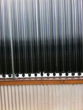 Corrugated galvanized steel siding mimics the undulations of the solar hot water collection tubes.