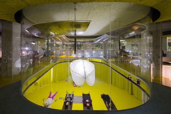 The table can be hoisted out of the way for events. Yellow epoxy-painted floors provide a durable and multifunctional surface for yoga and other activities.