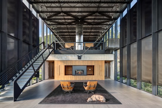 All systems and ducts in the double-height living room at the south end of the house (with its view to the kitchen and dining area on the floor above) run underneath a ceramic-tile, raised access floor to maintain an uncluttered interior.