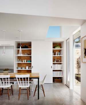The kitchen/dining space opens onto the backyard. A skylight and sliding glass doors admit plenty of daylight.