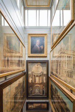 The lightwell over the Book Passage is lined with renderings, which have been returned to the locations they hung in during Soane’s life. Christopher William Hunnemann painted the portrait of Soane holding a compass in 1776.