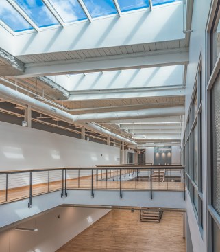 Architects created an open second floor to allow daylight to reach the first-floor central corridor.
