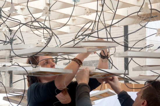 Annie Scherer and Aaron Zeligs from Atmospheric Delight suspend heating and lighting panels above their installation.