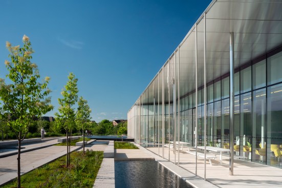 At the western edge of the site, terraced concrete walkways and benches with a series of pools create a buffer between the library and the street.