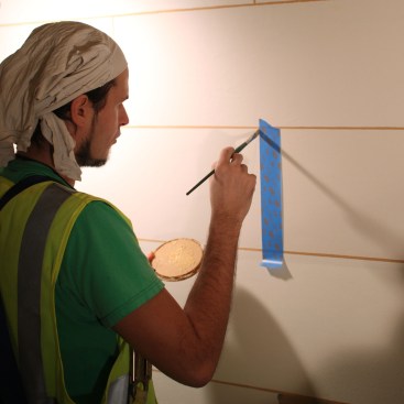 Restoration specialists paint interior joints on the walls and ceilings.