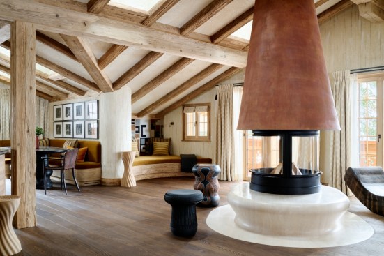 Caption: Interior of the residence features a liquid-metal fireplace designed by Francis Kéré and stools by Madoda Fani, a rocking chair by Cheick Diallo, silk dupion curtains and cushions by Aïssa Dione, and artwork by William Kentridge.