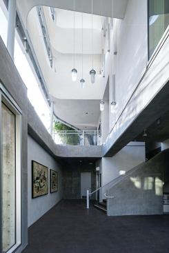 Concrete, metal, and industrial fixtures carry the exterior aesthetic through to the public spaces, such as this lobby that leads to the residential units on the floors above.