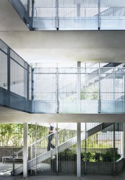 Much of the circulation in the building is accommodated by open-air pathways, with railings of perforated aluminum that nod to the building’s skin.