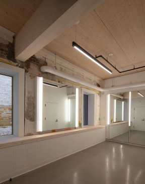 Originally a metal foundry, the Timber Adaptive Reuse Theater in Brooklyn, N.Y., has been transformed into a new developmental space for theater artists. The project exemplifies low-carbon design through adaptive reuse while repurposing removed building materials to create architectural features and minimizing the use of virgin materials. The structural insertions leverage low-carbon alternatives to standard construction practices by introducing sustainably forested mass timber.
