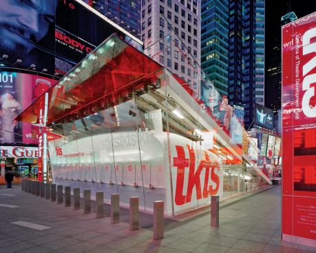 Impressive glass engineering continues at the front of the ticket booth, where the glass stringer beams connect to a cantilevered glass canopy, made from the same red-tinted glass as the staircase. 