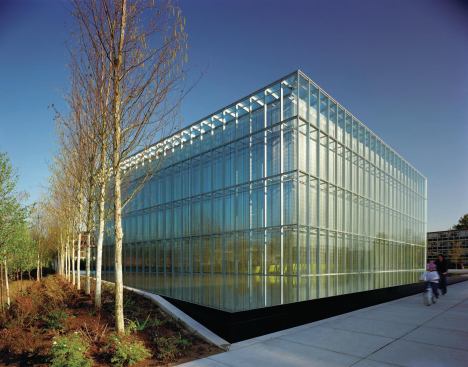 A double-wall façade addresses acoustic isolation, thermal insulation, and daylight control. A vertical stainless steel screen provides shading, thermal comfort, and ability to harvest heat.