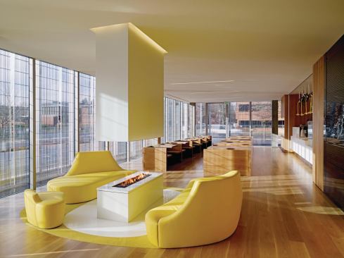 The face features a four-sided gas fireplace surrounded by a leather lounge seat suggesting the University of Oregon's "O."