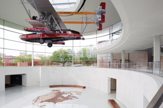 Suspended from the ceiling, the Carnaúba is the dominant visual element of Fortaleza Hall. Despite its size, the plane actually puts less stress on the roof structure than winter snow will. Still, extra steel members were put in place and tied into the roofs main truss system, and a mechanism was installed to allow the plane to be raised and lowered at will. Most employees enter the new building on the lower level, emerging from a system of tunnels that allow them to move between campus buildings during the harsh Wisconsin winters. "The experience the staff have when they come out of the tunnel and into that main space is really opening up to the plane [and] the sky," Robinson says. "It's a really strong sense of light that draws you up to the ground level." And when they do emerge, their path to one of the staircases leading to ground level takes them over a floor mosaic of the western hemisphere, made from four different types of end-grain FSC-certified wood.