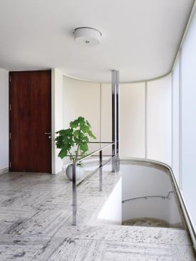 The street-level entrance leads into a marble-lined foyer with a curving stair that leads down to the main level of the house.